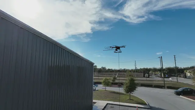 Cleaning drone flying beside a dark commercial metal building
