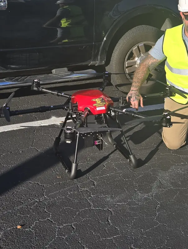 Red Strato-Capture Washing cleaning drone being prepared on a job site