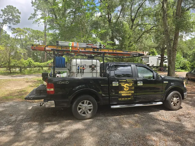 Black service truck with a hose reel and ladder rack