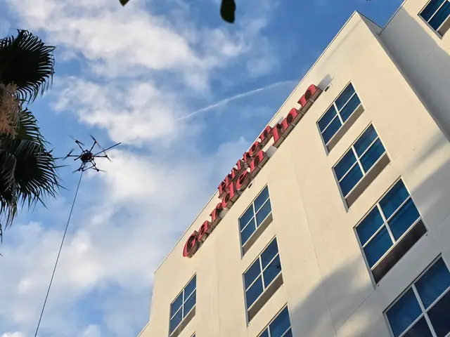 Cleaning drone working near the roofline under the hotel sign