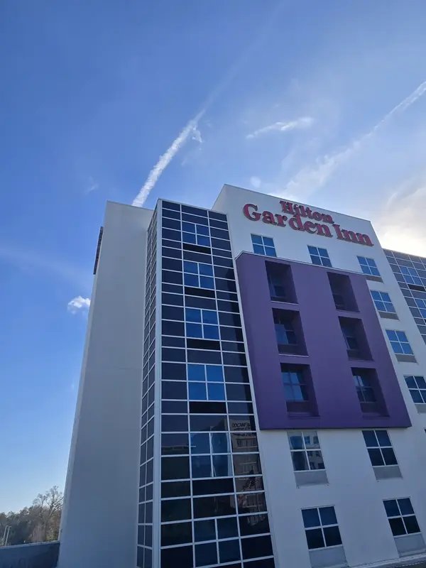 Hotel tower with blue glass, purple panels and a Hilton Garden Inn sign