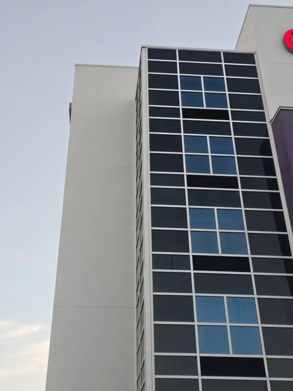 Hotel tower glass curtain wall beside a white façade