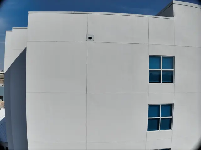 Close aerial view of a white hotel wall section and windows