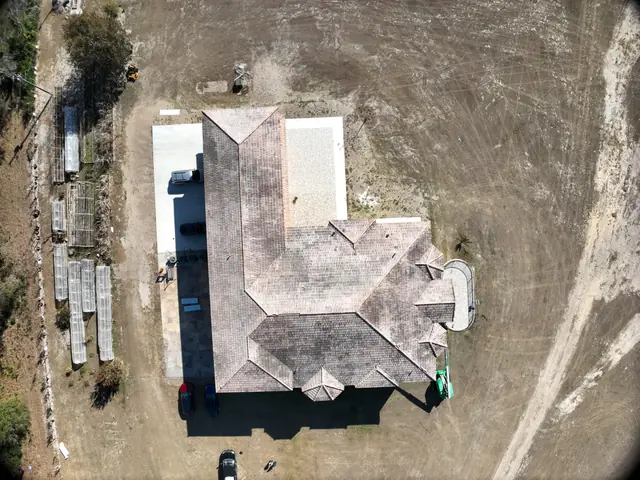 Aerial view of a large tile roof with dark staining before soft washing